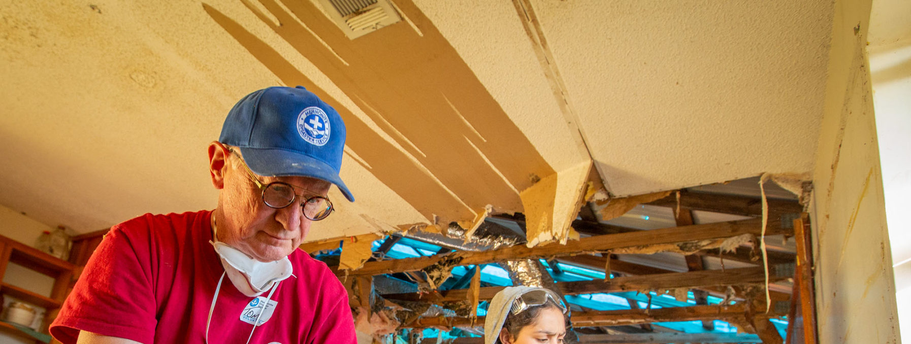 Photo of a young adult MDS volunteer installing house wrap on a recent project.